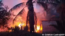 16.11.2023 Flames burn near a house after fires that went out of control during the burning of forests and pastures for agricultural purposes in Rurrunabaque, Beni Department, Bolivia, on November 16, 2023. (Photo by Cristian CASTRO / AFP)