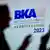 "BKA-Herbsttagung" und "Autumn Conference" 2023 steht in großen, blauen und schwarzen Buchstaben an der Wand, an der durch Lichtreflektionen die Schatten von Konferenz-Teilnehmern zu sehen sind. 