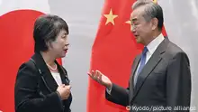 Japanese Foreign Minister Yoko Kamikawa (L) has a conversation with her Chinese counterpart Wang Yi ahead of their talks in Busan, South Korea, on Nov. 25, 2023. (Kyodo)