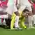 Schiedsrichter Felix Brych kniet mit schmerzverzerrtem Gesicht am Boden
