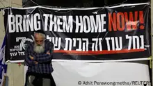 November 26, 2023**A man stands next to a banner as hostages are expected to be released by the Palestinian militant group Hamas, amid a hostages-prisoners swap deal between Hamas and Israel, in Tel Aviv, Israel, November 26, 2023. REUTERS/Athit Perawongmetha