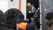 An emergency assistance worker holds out his hands to help a woman carrying a cat get out of a rescue vehicle An emergency assistance worker holds out his hands to help a woman carrying a cat get out of a rescue vehicle