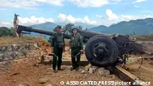 Members of the Myanmar National Democratic Alliance Army pose for a photograph in front of the seized howitzer in Kunlong township in Shan state, Myanmar, Sunday, Nov. 12, 2023. (The Kokang online media via AP)