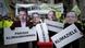 Protesters with signs and the faces of Germany's leading coalition politicians Protesters with signs and the faces of Germany's leading coalition politicians