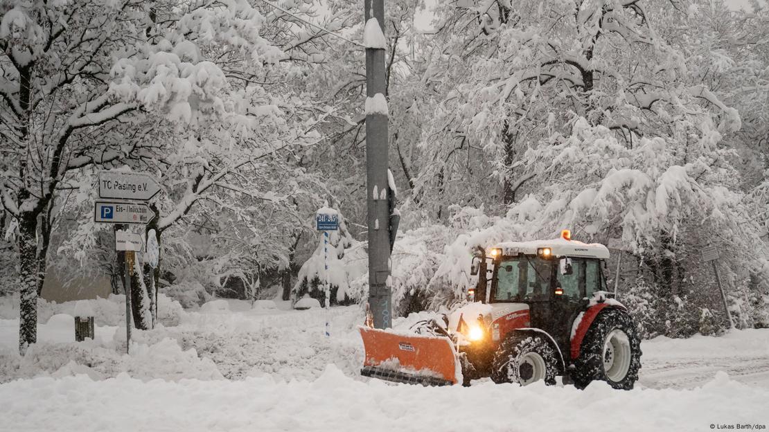 Un vehículo quitanieves retira masas de nieve de un aparcamiento en Múnich.