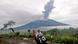 Motorists ride past by as Mount Marapi spews volcanic materials during its eruption Motorists ride past by as Mount Marapi spews volcanic materials during its eruption