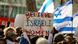 Eine Menschenmenge mit Israel-Flaggen und einem Schild: "Believe Israeli Women" Eine Menschenmenge mit Israel-Flaggen und einem Schild: "Believe Israeli Women"