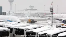 Ein Räum- und Streufahrzeug fährt im Schneetreiben auf dem Flughafen. Die Sperrung des Flugbetriebes am Münchner Flughafen ist wegen starker Schneefälle bis 03.12.2023 um 6.00 Uhr verlängert worden. +++ dpa-Bildfunk +++