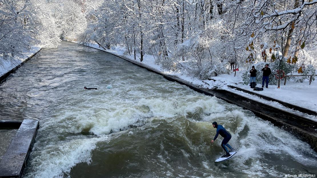 Pessoa surfa na onda do Eisbach em paisagem nevada