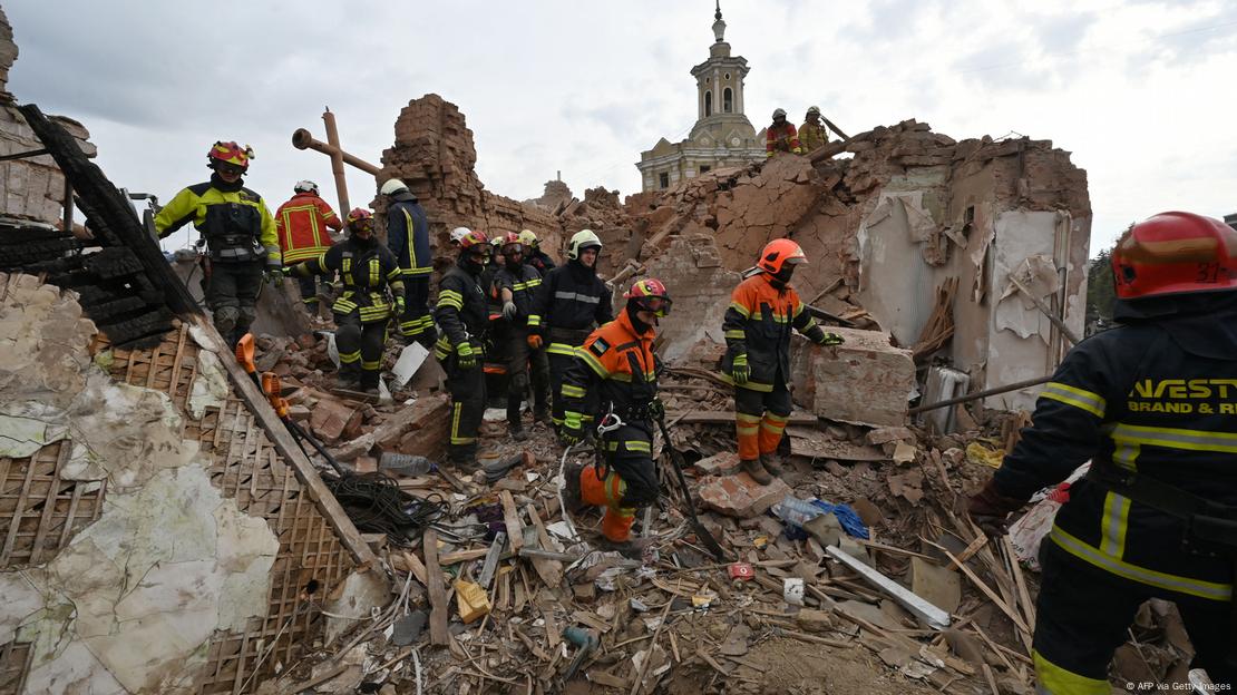 Rettungskräfte stehen auf einer Hausruine