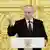 Russlands Präsident Wladimir Putin an einem Rednerpult vor einer goldenen Wand