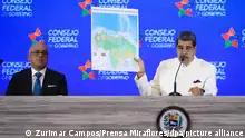 05/12/2023**Auf diesem vom venezolanischen Präsidentenamt zur Verfügung gestellten Bild zeigt Nicolas Maduro (r), Präsident von Venezuela, eine Karte des Landes bei einer Regierungssitzung. Nach einer nicht bindenden Volksabstimmung hat der autoritäre venezolanische Staatschef den Anspruch seines Landes auf einen Teil des Nachbarstaats Guyana unterstrichen. (zu dpa «Nach Volksbefragung: Maduro bekräftigt Anspruch auf Teil von Guyana») +++ dpa-Bildfunk +++