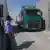 Policial observa caminhão verde em passagem por posto de fronteira