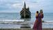 Seorang perempuan bersama anaknya melihat perahu yang membawa pengungsi Rohingya ke Pantai Laweueng di Aceh pada 10 Desember 2023 Seorang perempuan bersama anaknya melihat perahu yang membawa pengungsi Rohingya ke Pantai Laweueng di Aceh pada 10 Desember 2023