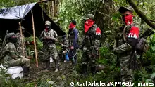 Members of the Ernesto Che Guevara front, belonging to the National Liberation Army (ELN) guerrillas, stand at an improvised camp in the Choco jungle, Colombia, on May 23, 2019. - The ELN or National Liberation Army is Colombia's last rebel army and one of the oldest guerrillas in Latin America. (Photo by Raul ARBOLEDA / AFP) (Photo credit should read RAUL ARBOLEDA/AFP via Getty Images)