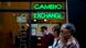 People sitting in front of a money exchange shop in Buenos Aires, Argentina.