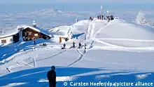 Ein Skitourengeher in den Ammergauer Alpen, im Hintergrund die Hörnlehütte und der Zeitberg (1404 Meter). Das schöne Wetter lockte am Sonntag Wintersportler in Scharen auf den beliebten Ausflugsberg, obwohl das örtliche kleine Skigebiet derzeit noch geschlossen hat. +++ dpa-Bildfunk +++