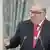 Russian oligarch Alisher Usmanov speaking into a microphone