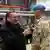 Deutschlands Verteidigungsminister Boris Pistorius steht vor zwei Soldaten in Uniform und pinnt einem von ihnen einen Orden an.