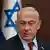 Prime Minister Benjamin Netanjahu seen with an Israeli flag behind him