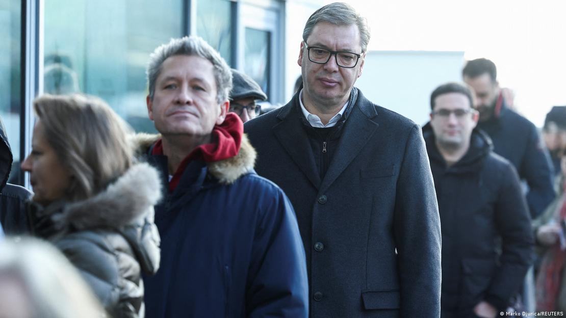 Serbian President Aleksandar Vucic waits in a queue to cast his vote