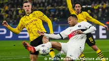 PSG's Kylian Mbappe, centre, and Dortmund's Nico Schlotterbeck, left, challenge for the ball during the Champions League Group F soccer match between Borussia Dortmund and Paris Saint-Germain at the Signal Iduna Park in Dortmund, Germany, Wednesday, Dec. 13, 2023. (AP Photo/Martin Meissner)