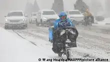 ©/MAXPPP - DALIAN, CHINA - JANUARY 06: A food delivery courier for Ele.me rides a motorcycle along a road during a snowstorm on January 6, 2021 in Dalian, Liaoning Province of China. (Photo by Wang Hua/VCG)