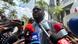 Jeremias Langa, President of MISA Mosambique, stands on a street in Muputo surrounded by journalists holding microphones