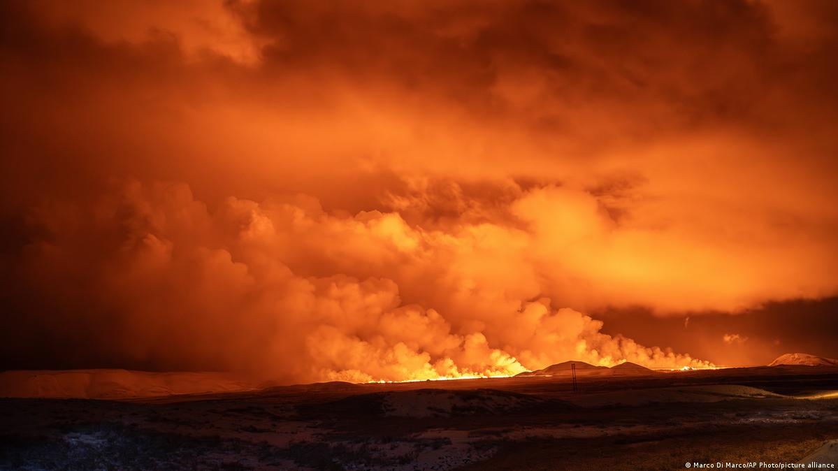 Llamas color naranja iluminan las humaredas en el cielo nocturno.