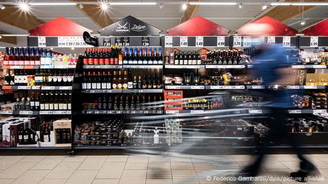 Pessoa anda em supermercado empurrando carrinho Pessoa anda em supermercado empurrando carrinho