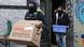Police officers carry boxes out of an apartment building during a search operation Police officers carry boxes out of an apartment building during a search operation