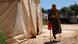 Fatima Ahmed Al-Hassan, a Syrian girl whose leg was amputated, stands on her crutches in front of a tent Fatima Ahmed Al-Hassan, a Syrian girl whose leg was amputated, stands on her crutches in front of a tent