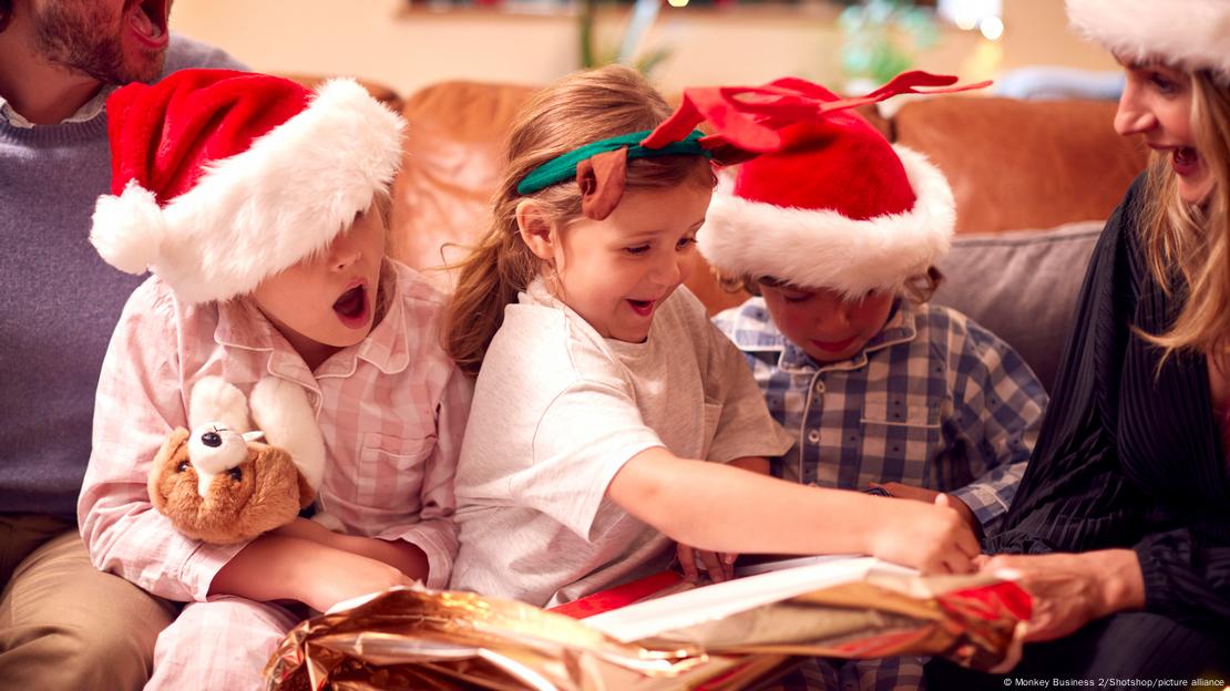 Unos niños abriendo regalos con sombreros de Papá Noel. Unos niños abriendo regalos con sombreros de Papá Noel.