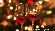 Rose wine in shiny wineglass in front of Christmas tree JTF01754 
