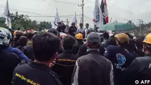Indonesia Morowali Industrial Park (IMIP) workers protest against their working conditions outside the facility in Bungku, South Sulawesi, on December 27, 2023, after at least 18 people were killed by an explosion at the Chinese-funded nickel-processing plant on December 23. The accident occurred December 23 as workers repaired a furnace at a plant owned by PT Indonesia Tsingshan Stainless Steel (ITSS) in the Morowali Industrial Park on Sulawesi island. (Photo by AFP)