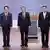 The Taiwanese politicians in suits stand on a stage