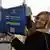 Blonde Frau mit Brille hält einen blauen Beutel hoch, Aufschrift: Visaliberalisierung für Kosovo #OhneVisa