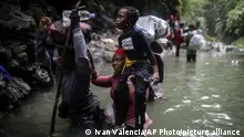 09/05/2023**FILE - Haitian migrants wade through water as they cross the Darien Gap from Colombia to Panama in hopes of reaching the U.S., May 9, 2023. Hundreds of thousands of migrants have risked the dangerous trek through the jungle in recent years and the flow this year is on a record pace. (AP Photo/Ivan Valencia, File)