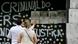 Duas pessoas em frente a fotos no muro de onde ficava a boate Kiss Duas pessoas em frente a fotos no muro de onde ficava a boate Kiss