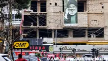 TOPSHOT - A picture depicting Hassan Nasrallah, the leader of the Lebanese Shiite movement Hezbollah, hangs on a building near the site of an Israeli strike targeting Hamas deputy leader Saleh al-Aruri in the southern suburb of Beirut on January 3, 2024. Aruri was killed on January 2 along with his bodyguards in a strike by Israel, which has vowed to destroy Hamas after the movement's shock October 7 attacks. Israel has previously announced the deaths in Gaza of Hamas commanders and officials during the war, but Aruri is the most high-profile figure to be killed, and his death came in the first strike on the Lebanese capital since hostilities began. (Photo by ANWAR AMRO / AFP) (Photo by ANWAR AMRO/AFP via Getty Images)