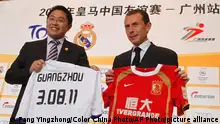 Real Madrid's former football striker Emilio Butragueno (R) and Guangzhou Evergrande Football Club president Liu Yongzhuo exchange gifts during a Real Madrid China Tour press conference in Guangzhou in south China's Guangdong province on Thursday, May 26, 2011. Spanish League soccer team Real Madrid announced they will play two pre-season friendly matches against Tianjin Teda team and Guangzhou Evergrande team in China in August 2011.(Photo By Fang Yingzhong/Color China Photo/AP Images)