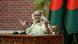 Sheikh Hasina gesticula con las manos mientras habla ante dos micrófonos. Sheikh Hasina gesticula con las manos mientras habla ante dos micrófonos.