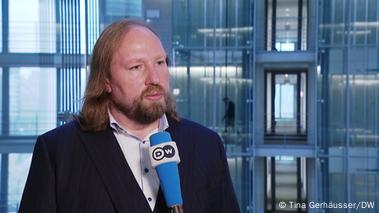 A man with long hair (Anton Hofreiter) behind a microphone of the DW