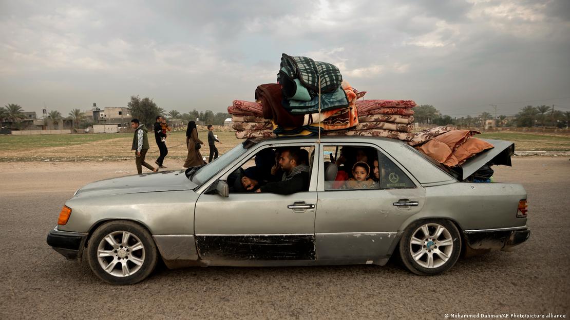 Familje palestineze largohet në Khan Junis pas ofensiv tokësore të Izraelit në luftë kundër Hamasit, 27 dhjetor, familja në makinë mbushur plot me familjarë, në dritare sheh një vajzë e vogël, mbi makinë janë vendosur stivë batanije