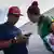 Un migrante colombiano mira en su celular, junto a su pareja.
