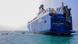 A freight ship on the Red Sea with smaller boats encircling it A freight ship on the Red Sea with smaller boats encircling it