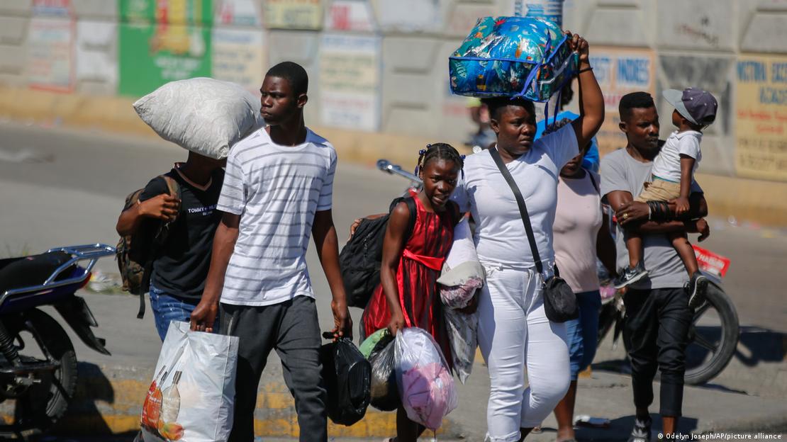 Residentes del barrio de Solino, que fueron desplazados de sus hogares debido a enfrentamientos entre bandas armadas, buscan refugio mientras caminan por una calle en la comunidad Carrefour en el sur de Puerto Príncipe.