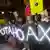 People hold a sign made of LED lights that says ''Not A Hoax'' during a rally in San Diego