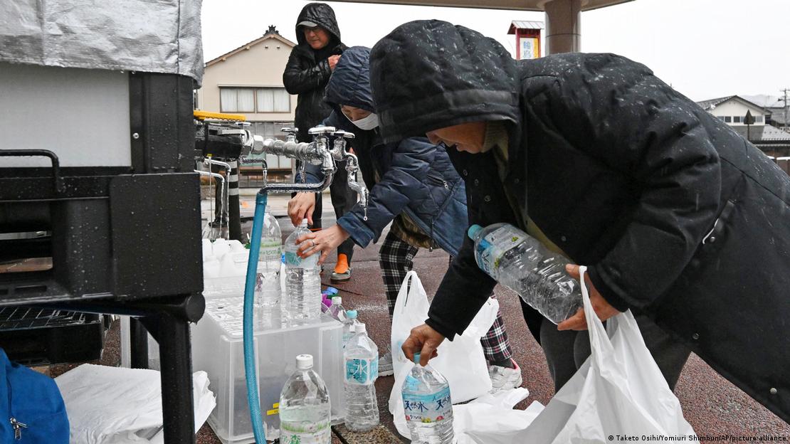 La gente obtiene agua frente a un refugio en la ciudad de Wajima. (21.01.2024)