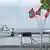 A soldier stands at attention near the port of Male in the Maldives in an archive photo in which Maldives flags and a coast guard vessel can be seen